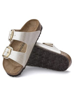 Semelle des Sandales Birkenstock Arizona Big Buckle en largeur étroite. Les deux brides réglables sont en Birko-Flor® blanc nacré satiné (Graceful Pearl White) avec de grandes boucles en métal argenté, reposant sur une semelle anatomique en liège et cuir velours.