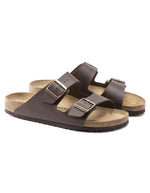 Paire de Sandales anatomiques à deux brides marron foncé pour homme et femme, tige en Birko-Flor avec boucles réglables et semelle en liège, modèle Arizona Narrow Dark Brown de Birkenstock.