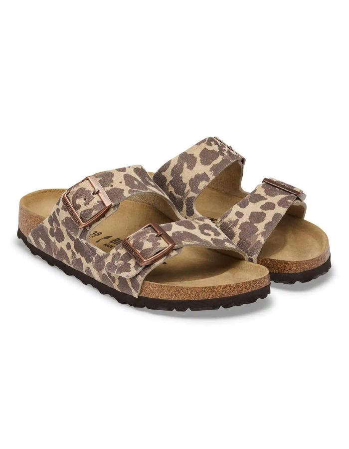 Paire de Sandales d'été pour femme modèle Arizona de la marque Birkenstock, en cuir velours à imprimé léopard Leo Sandcastle beige et marron. Présentent deux brides larges réglables avec des boucles en métal noir et la célèbre semelle anatomique en liège naturel.