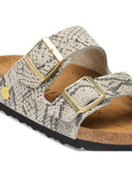 Boucle des Sandales pour pieds fins en largeur Narrow, modèle emblématique Arizona Rivet Logo de la marque Birkenstock. Confectionnées en cuir velours souple de couleur claire beige huître Snake Oyster, elles présentent deux brides horizontales ajustables avec boucles en métal, un rivet logo et la célèbre semelle anatomique marron en liège naturel