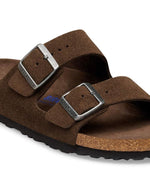 Boucle des Sandales Birkenstock modèle Arizona avec chaussant étroit. Présente deux brides ajustables en cuir velours souple de couleur marron foncé Carafe avec des boucles en métal assorties, montées sur la célèbre semelle anatomique en liège avec lit de pied souple.