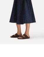 Vue de profil des Sandales Birkenstock modèle Arizona avec chaussant étroit. Présente deux brides ajustables en cuir velours souple de couleur marron foncé Carafe avec des boucles en métal assorties, montées sur la célèbre semelle anatomique en liège avec lit de pied souple.