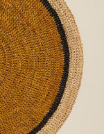 Détail du Set de table rond Globe par Maison Sarah Lavoine, confectionné en raphia naturel tressé à la main. Centre de couleur jaune Safran vibrant et bordure contrastée en coloris naturel. Design artisanal fabriqué à Madagascar, diamètre 38 cm.