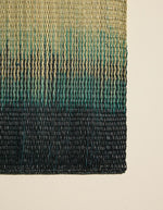 Détail du Set de table rectangulaire Orée Forêt par Maison Sarah Lavoine. Tressage artisanal en fibres naturelles de Carex avec dégradé vert forêt évoquant des silhouettes d'arbres, 45 x 30 cm