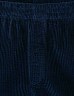 Tissu du Short mi-long pour homme en velours côtelé bleu marine foncé Navy Vintage, modèle Padow de la marque American Vintage. Présente une coupe ample et droite avec une taille élastiquée et des poches discrètes intégrées sur les côtés.