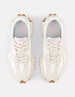 New Balance 327 Moonbeam December Sky sneakers, daim et textile blanc cassé avec logo N rose pâle et semelle crantée marron.