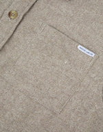 Poche de la Surchemise ample en flanelle de laine mélangée gris ciment pour homme, modèle Monge de la marque Maison Labiche. Présente une coupe droite large avec col chemise, fermeture boutonnée et deux poches plaquées sur la poitrine.