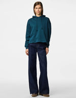 Silhouette avec le Sweatshirt à capuche uni pour femme modèle Chilli de la marque Pieces. Coupe droite de couleur bleu marine très foncé et profond Reflecting Pond, doté d'une capuche et de manches longues