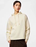Vue de face du Sweatshirt à capuche uni pour femme modèle Chilli de la marque Pieces. Coupe droite de couleur blanc cassé grisé White Pepper, doté d'une capuche avec cordons et de manches longues.