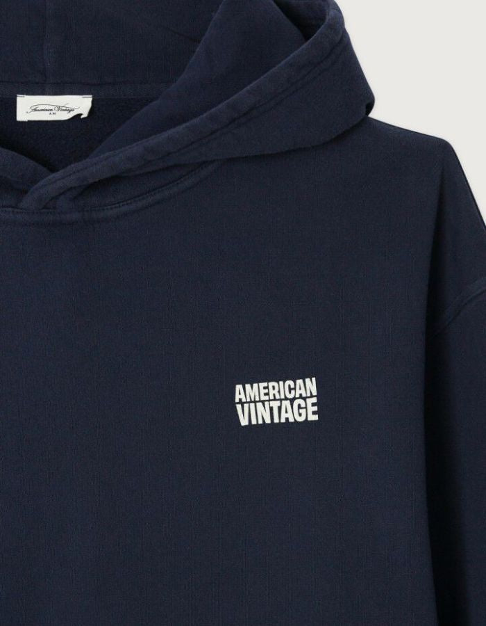 Col du Sweat à capuche oversize bleu marine délavé pour homme en molleton coton doux avec poche kangourou et finition peau de pêche, modèle Plizzy couleur Navy Vintage de la marque American Vintage
