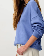 Profil du Sweatshirt oversize pour femme en molleton chiné bleu ciel avec col rond boutonné et jacron cuir au dos, modèle Sweat Chebbi couleur Italian Blue de la marque Sessùn.