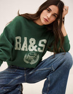 Mannequin portant un sweatshirt court ample vert émeraude Ba&sh avec logo et un jean décontracté.