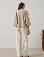 Sweatshirt Iksan beige chiné oversize à manches courtes et surpiqûre dos, porté avec un pantalon clair.