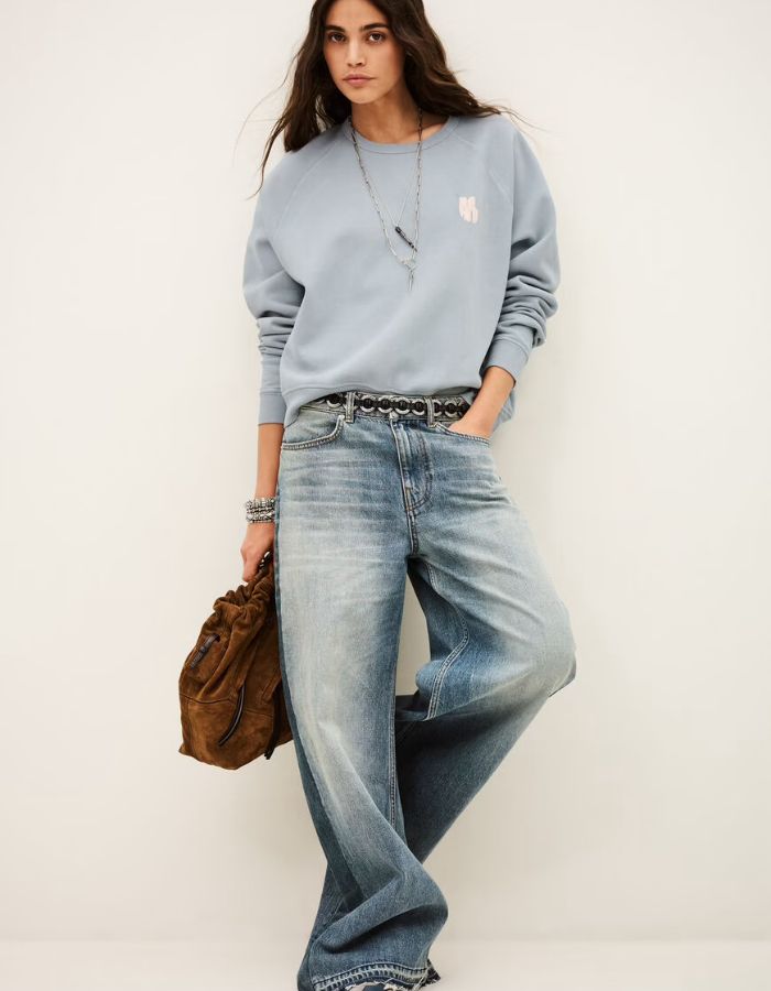 Silhouette avec le Sweat-shirt pour femme en molleton doux de couleur bleu glacier pastel, modèle Swing de la marque Ba&sh. Présente une coupe ample loose avec col rond et manches raglan, rehaussée de surpiqûres overlock et d'une impression signature Ba&sh texturée sur la poitrine.