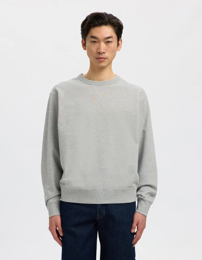 Vue de face du Sweatshirt col rond pour homme en coton biologique gris clair chiné Light Grey Melange, modèle Relaxluke de la marque SELECTED HOMME. Présente une coupe droite avec finition en bord-côte au col, aux poignets et à la taille