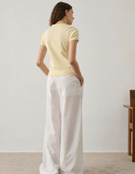 Femme portant un tee-shirt Aristide jaune pâle en coton biologique, coupe étroite, manches courtes, col rond.