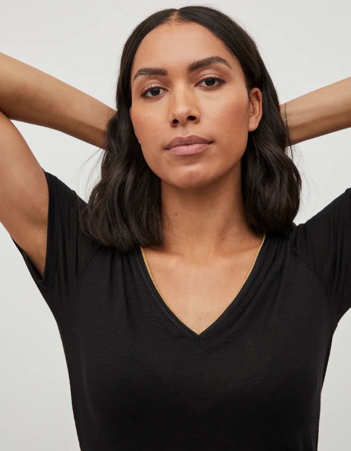Col du T-shirt noir uni pour femme modèle Noel de la marque Vila. Design classique à manches courtes et col en V, réalisé dans une maille jersey fluide et extensible
