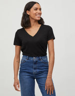Silhouette avec le T-shirt noir uni pour femme modèle Noel de la marque Vila. Design classique à manches courtes et col en V, réalisé dans une maille jersey fluide et extensible