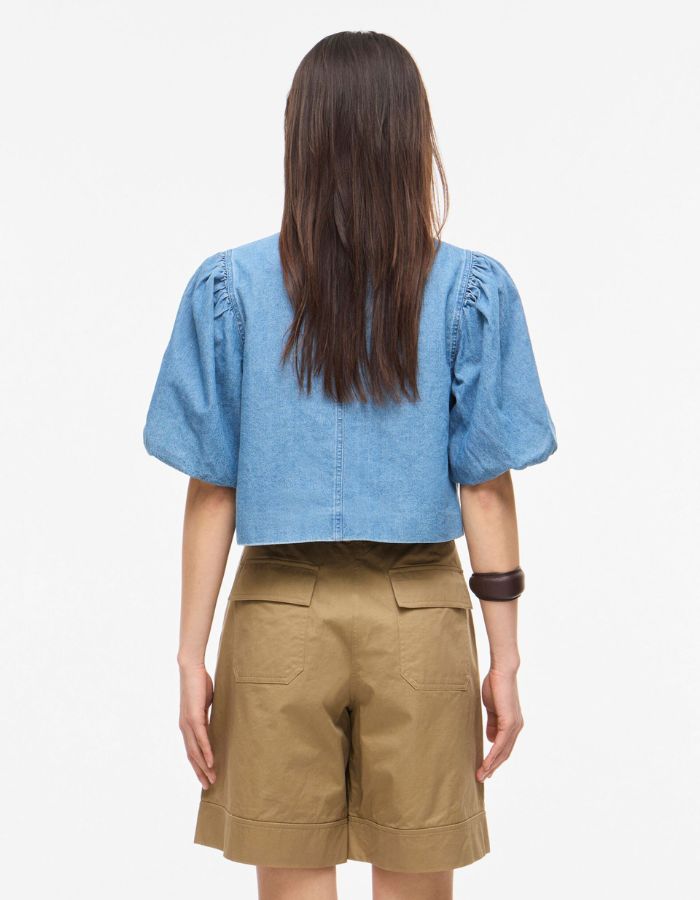 Dos du Top court en jean bleu clair Delila de ROUGE EDIT. Modèle à manches courtes bouffantes, encolure ronde et fermeture par boutons sur le devant. Coupe regular en coton denim.
