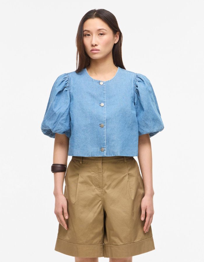 Top court en jean bleu clair Delila de ROUGE EDIT. Modèle à manches courtes bouffantes, encolure ronde et fermeture par boutons sur le devant. Coupe regular en coton denim.