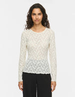 Silhouette de face avec le Top ajusté à manches longues pour femme, modèle Fay de la marque Vila. Tissu en mesh extensible coloris Regret (nuance foncée) avec des détails raffinés en dentelle et un col rond classique