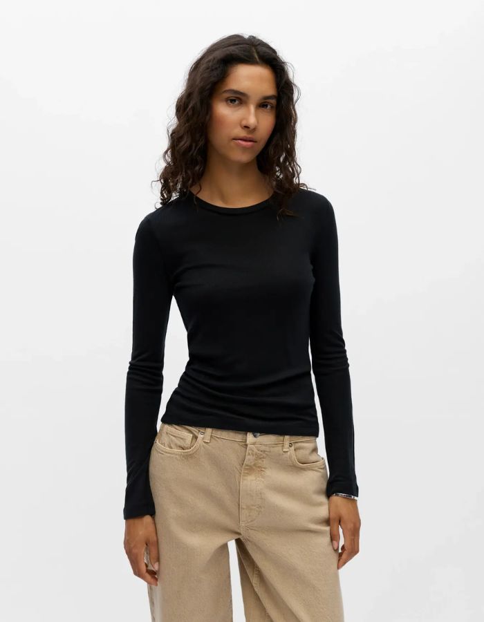 Devant du T-shirt à manches longues pour femme en jersey fluide noir uni, modèle Alma de la marque Object. Présente une coupe droite classique ajustée avec un col rond dégagé, conçu dans une matière douce à l'aspect légèrement satiné.