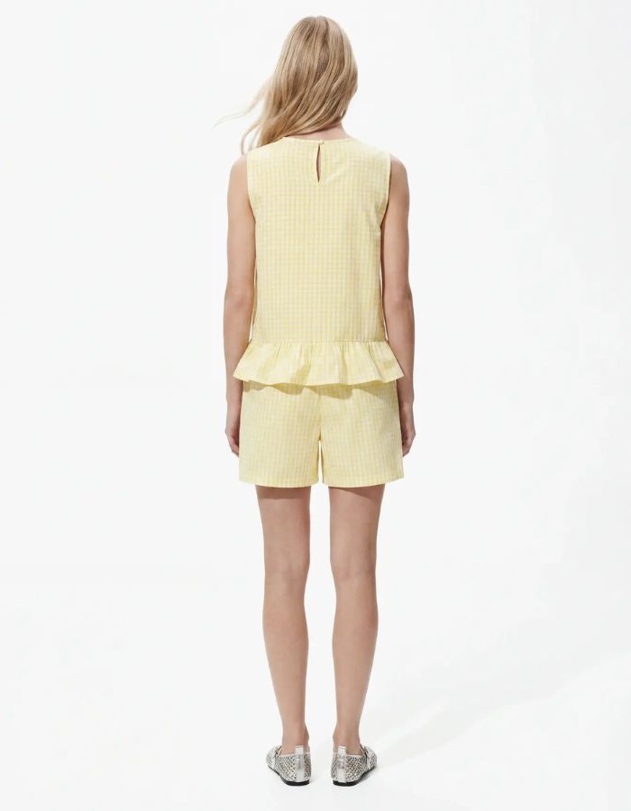 Silhouette de dos avec le Top sans manches Bibby de la marque PIECES avec motif Vichy jaune et blanc. Coupe Regular Fit avec découpe à la taille et col rond. Fabriqué en coton biologique et matières recyclées.