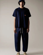 Silhouette de face avec le T-shirt confort unisexe en coton lourd bleu nuit noir avec col rond et patch cœur en feutrine sur la poitrine, modèle Heritage Tee couleur Night de la marque Sweet Pants.