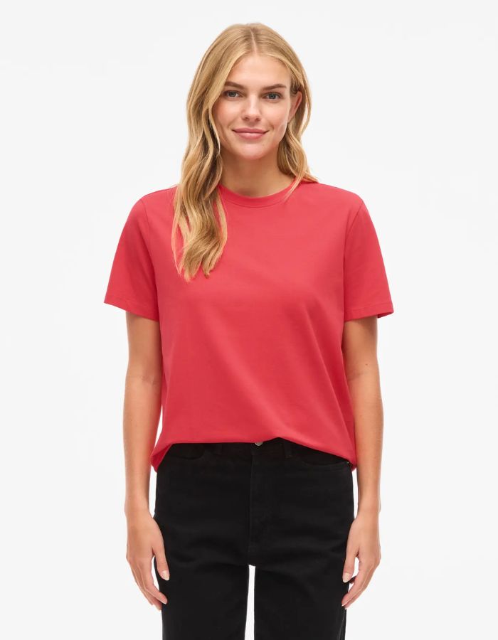 Femme blonde portant un t-shirt rouge corail en jersey de coton biologique à manches courtes et col rond.