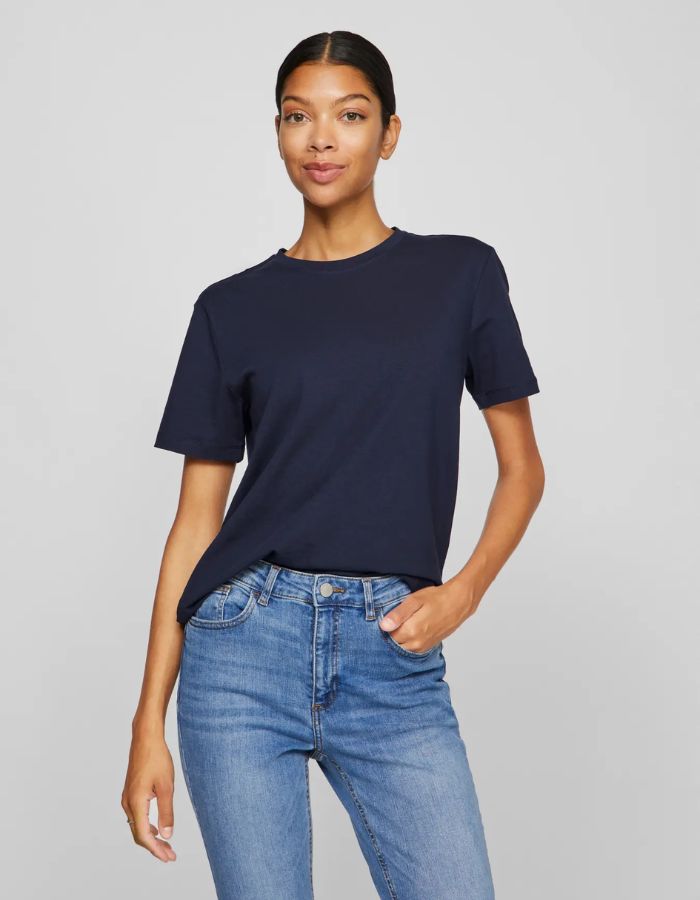 Femme portant un t-shirt Nora Vila bleu marine en jersey de coton bio, coupe droite, manches courtes et encolure ronde.