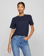 Femme portant un t-shirt Nora Vila bleu marine en jersey de coton bio, coupe droite, manches courtes et encolure ronde.