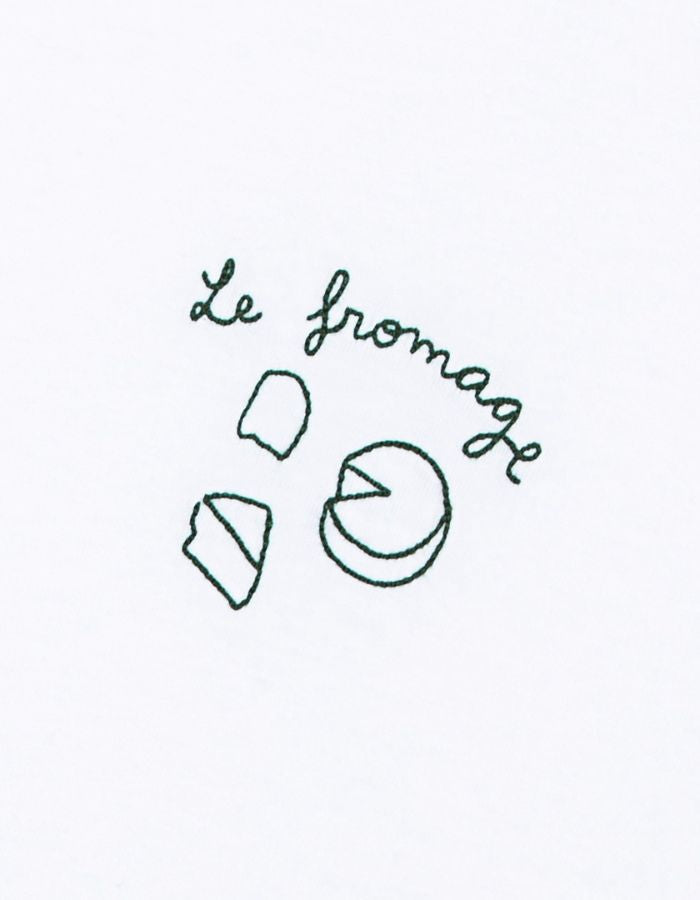 Patch du T-shirt blanc à manches courtes pour homme en coton biologique, modèle Popincourt de la marque Maison Labiche. Présente une coupe droite avec col rond et une petite broderie fine rouge et noire 'Le Fromage' sur le côté gauche de la poitrine.