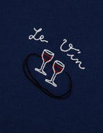 Patch du T-shirt bleu marine à manches courtes pour homme en coton biologique, modèle Popincourt de la marque Maison Labiche. Présente une coupe droite avec col rond côtelé et une petite broderie fine 'Wine' sur le côté gauche de la poitrine.