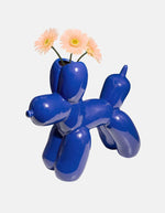 Fleurs roses dans le Vase en céramique bleu électrique Bobby par la marque DOIY. Design sculptural et géométrique avec des découpes graphiques modernes, mesurant 25 cm de longueur.