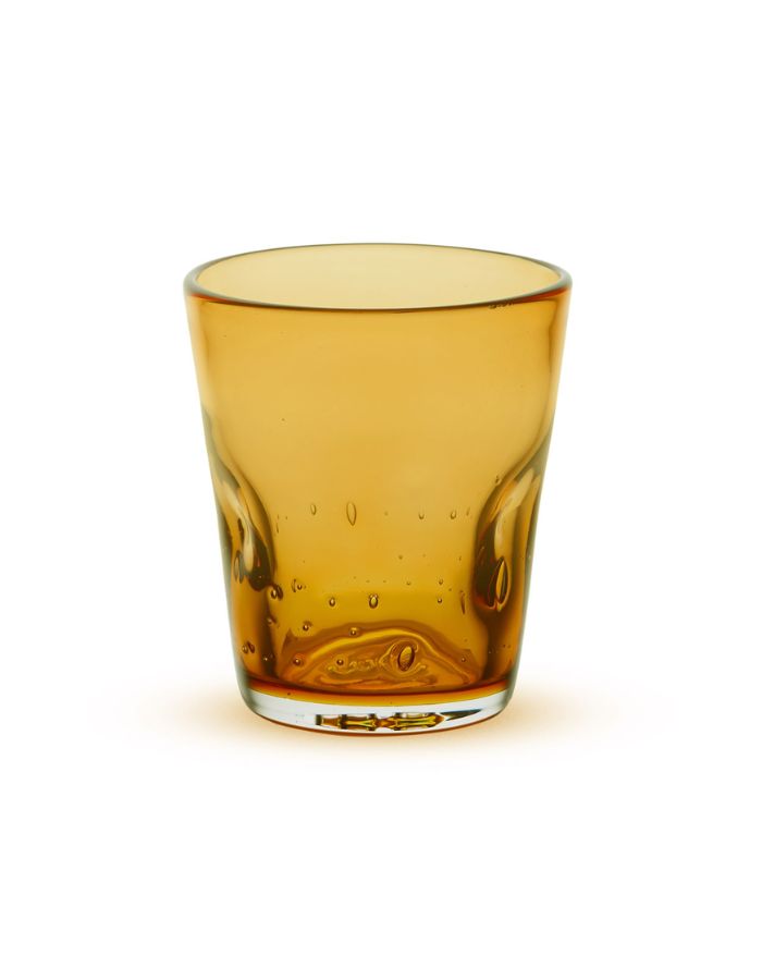 Verre à eau artisanal Memento Dune couleur ambre, en pâte de verre soufflée à la bouche avec des ondulations naturelles et une forme pincée ergonomique.