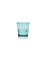 Vue de face du verre à eau Memento Dune couleur Aqua en verre soufflé artisanal, forme ondulée et ergonomique avec reflets bleu lagon.