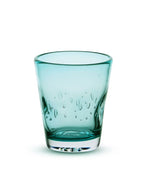 Verre à eau Memento Dune couleur Aqua en verre soufflé artisanal, forme ondulée et ergonomique avec reflets bleu lagon.