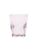 Vue du dessous du verre à eau artisanal Memento Dune couleur rose translucide, en verre soufflé à la bouche avec relief ondulé ergonomique et reflets poudrés.