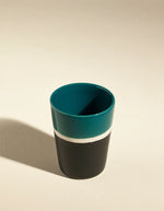 Vue du dessus du Verre en grès artisanal Sicilia par Maison Sarah Lavoine. Intérieur émaillé Bleu Sarah brillant et extérieur noir mat (Radis Noir). Fabriqué à la main en France par l'atelier Jars, hauteur 7,5 cm.