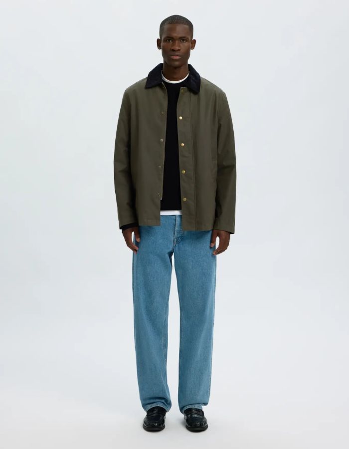 Silhouette avec la Veste courte pour homme en coton huilé kaki déperlante avec col rabattu et fermeture à boutons-pression, modèle Veste Kaki Coton Huilé Walter de la marque Selected Homme avec tissu Halley Stevensons.