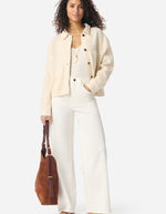 Veste Denver écru en laine et coton, coupe courte, col chemise, poches poitrine, portée par une femme.