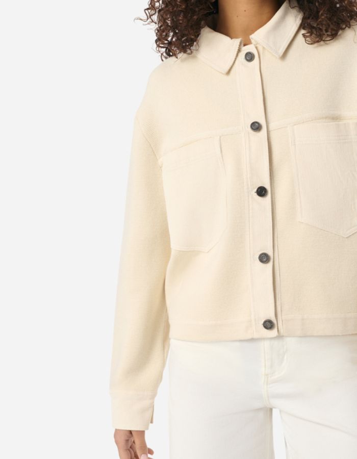 Veste Denver écru en laine et coton, coupe courte, col chemise, poches poitrine et boutons foncés.