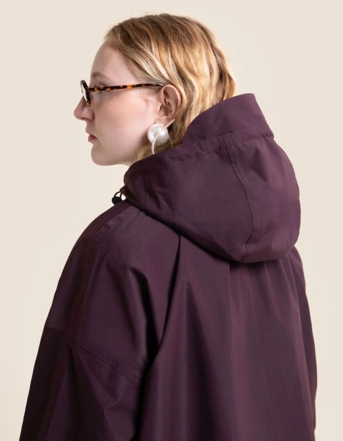 Capuche de la Veste imperméable oversize mixte violette cassis avec détails plissés, effet bouffant et capuche amovible, modèle Garance couleur Cassis de la marque Flotte.