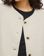 Col de la Veste courte pour femme effet moumoute fausse fourrure de couleur beige écru, modèle Ada Teddy Jacket de la marque VILA. Présente un col chemise rabattu, des manches longues et une fermeture boutonnée sur le devant.