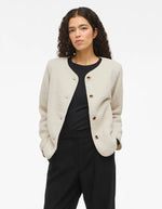 Silhouette avec la Veste courte pour femme effet moumoute fausse fourrure de couleur beige écru, modèle Ada Teddy Jacket de la marque VILA. Présente un col chemise rabattu, des manches longues et une fermeture boutonnée sur le devant.