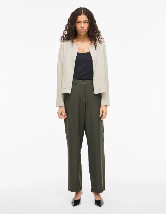 Veste Beige Zippée Garden Vila en maille côtelée, coupe courte, col rond, portée par une femme.