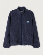 Veste zippée à manches longues pour homme de couleur bleu nuit foncé Astre Chiné, modèle Hoktown de la marque American Vintage. Confectionnée dans une matière épaisse effet mouton retourné shearling, elle présente un col montant bas, une fermeture éclair, deux poches zippées et un écusson logo AMV sur la poitrine.