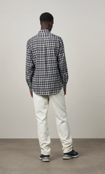 Homme de dos portant une chemise Pitt à carreaux carbone en flanelle de coton et un pantalon clair.